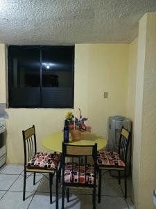 een keuken met een tafel en stoelen en een raam bij Casa relax in Quito