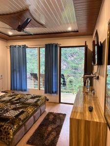 - une chambre avec un lit et une grande fenêtre dans l'établissement Kedar Valley Resorts Kedarnath, à Phata