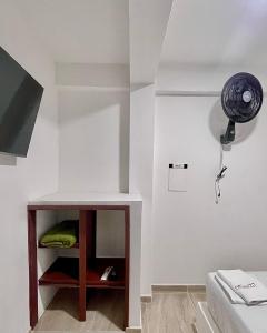 Cette chambre comprend un lit et une étagère avec un ventilateur. dans l'établissement Hotel ZT, à Mariquita