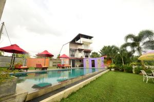 a villa with a swimming pool in front of a house at Kurulu Villa Baddegama in Galle