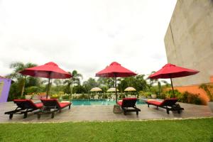a group of chairs and umbrellas next to a pool at Kurulu Villa Baddegama in Galle
