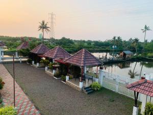 Une rangée de maisons près d'une rivière dans l'établissement Oceanpearl Kalapura Resort, à Ernakulam