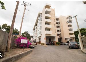 a parking lot with cars parked in front of a building at Finest Accommodation Oxford Manor One Bedroom Apt # 27 in Kingston