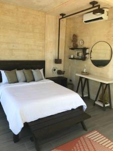 1 dormitorio con cama, mesa y espejo en The LivingSpace Villa, en Islas Camotes
