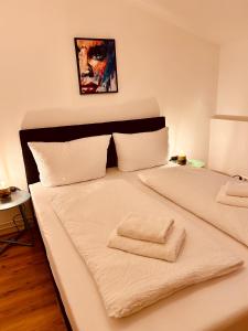 - un lit blanc avec 2 serviettes dans l'établissement Apartments Alina, à Rust