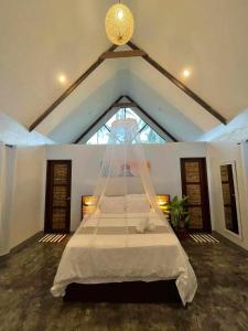 a bedroom with a large bed with a window at EPBliss Siargao in General Luna