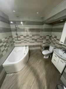 e bagno con vasca, servizi igienici e lavandino. di Olympic Hotel a Gyumri