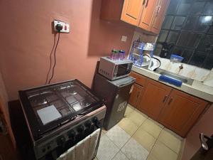 a kitchen with a stove and a microwave at Tenet Upper Kabete Homes in Nairobi