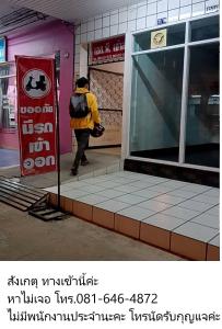 a person with a backpack walking past a store at SP House RoiEd in Roi Et