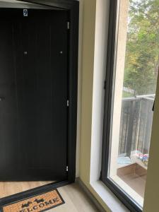 a black door in a room with a window at Studio Zori in Burgas City