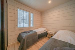 a room with two beds and a window at Villa Alvo in Kittilä