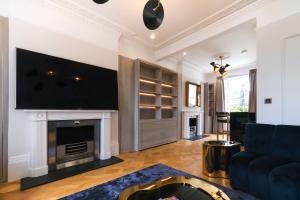 sala de estar con chimenea y TV de pantalla plana en Luxurious Central 4BR Mansion 2 min from Hyde Park, en Londres