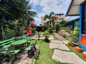 Kasithorn Apartment&Hotel في بيتشابون: حديقة بها طاولة وكراسي ومبنى