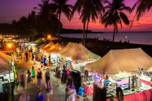 a group of people walking around a market at night at Zen Ocean Pebble 1-BR/1-BA Sea View Retreat in Darwin +16 photos