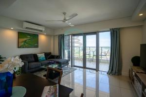 a living room with a couch and a balcony at Zen Ocean Pebble 1-BR/1-BA Sea View Retreat in Darwin