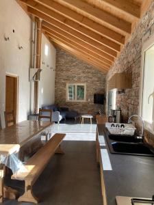 Il comprend une cuisine et un salon avec un mur en pierre. dans l'établissement La Gardette, à Le Freney-dʼOisans
