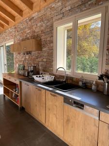 a kitchen with a sink and a brick wall at La Gardette in Le Freney-dʼOisans