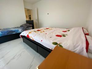 a bedroom with a bed with a white sheet with flowers at Attika Loft Wohnung 3.5 Zi. 110m2 Neu Bau in Obergösgen