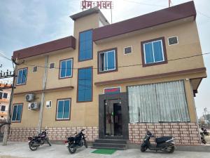 a building with three scooters parked in front of it at Prem Bhawan Guest House in Khātu