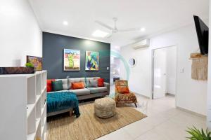 un salon avec un canapé et une chaise dans l'établissement Zenhouse Vista Elegant 5BR Coastal Haven, à Leanyer