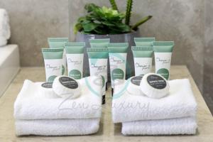 - un ensemble de serviettes sur une table dans la salle de bains dans l'établissement Zenhouse Vista Elegant 5BR Coastal Haven, à Leanyer 53 autres photos