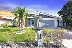 une maison avec garage dans une cour dans l'établissement Zenhouse Vista Elegant 5BR Coastal Haven, à Leanyer