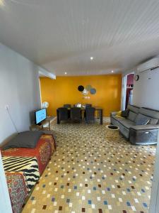a living room with a bed and a dining room at LASYMPHO - Séjour de repos à la campagne in Le François