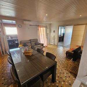 a living room with a table and a couch at LASYMPHO - Séjour de repos à la campagne in Le François