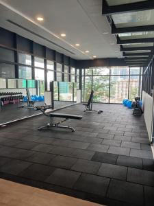 un gimnasio con varias cintas de correr y bancos en una habitación con ventanas en KUALA LAMPUR LUCENTIA RESIDENCE KLCC en Kuala Lumpur