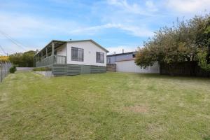 a large yard with a house and a fence at Old Sea Dog's Retreat in Coronet Bay