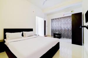 a bedroom with a large white bed and a window at OYO Home Cozy Home in Guwahati