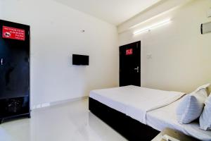 a bedroom with a bed and a red sign on the wall at Hotel O Home Cozy Home in Guwahati