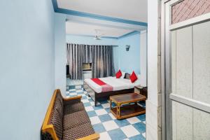 a bedroom with a bed and a couch in a room at Hotel O Crown Continental in New Delhi