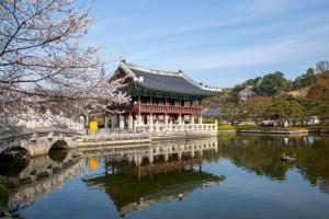 a chinese building on a bridge over a lake at Parkavenue Guesthouse in Seoul