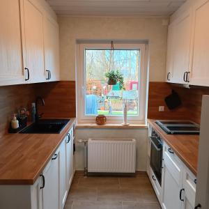 a kitchen with white cabinets and a window at Haus Irma in Hemmingstedt