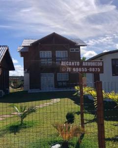 a house with a sign in front of a fence at Recanto Arvoredo in Entre Rios