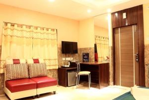 a hotel room with a red chair and a desk at SHREE KRISHNA HOTELS & RESORTS PVT LTD in Salua