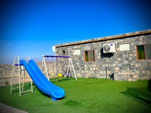 a playground with a slide in a yard at بيت السلام bayt alsalam in Sa‘ab Banī Khamīs