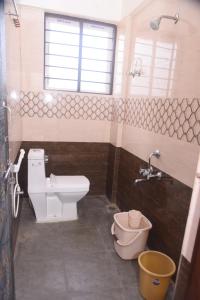 a bathroom with a toilet and a sink at Shiva Deluxe Lodge in Shimoga