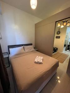 a bedroom with a bed with two slippers on it at Staycation in the South (Near Manila Airport) in Manila