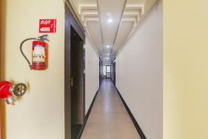 a long hallway with a fire extinguisher on the wall at FabExpress Grand Inn in Vibhuti Khand