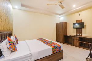 a bedroom with a bed and a flat screen tv at FabExpress Grand Inn in Vibhuti Khand