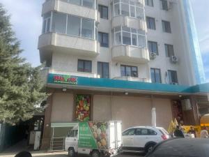 um edifício com uma carrinha estacionada em frente a um edifício em Cozy apartment 3 em Samarkand