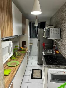 a kitchen with a stove and a microwave at APARTAMENTO CONFORTO in São Luís