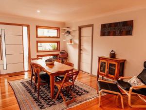 een woonkamer met een houten tafel en stoelen bij Luxury Mountain Valley Villa in Mt Evelyn in Mount Evelyn