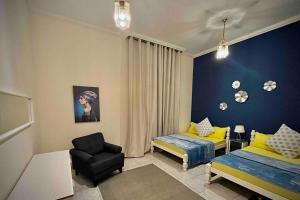 a bedroom with a bed and a chair and a couch at Brightful and joyful 4 bedroom villa in Dubai