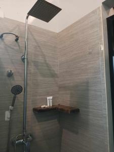 a shower with a wooden shelf in a bathroom at EPBliss Siargao in General Luna