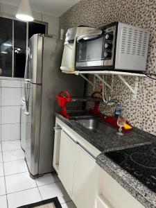 a kitchen with a stainless steel refrigerator and a microwave at APARTAMENTO CONFORTO in São Luís