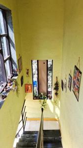 Cette chambre est dotée de murs jaunes et d'un escalier avec une fenêtre. dans l'établissement Bageecha B&B-Jal, à Alibaug