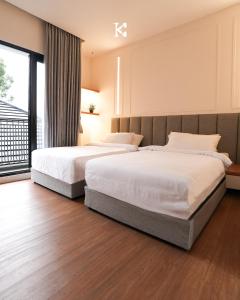 a bedroom with two beds and a large window at BUMINAKURA in Bandung